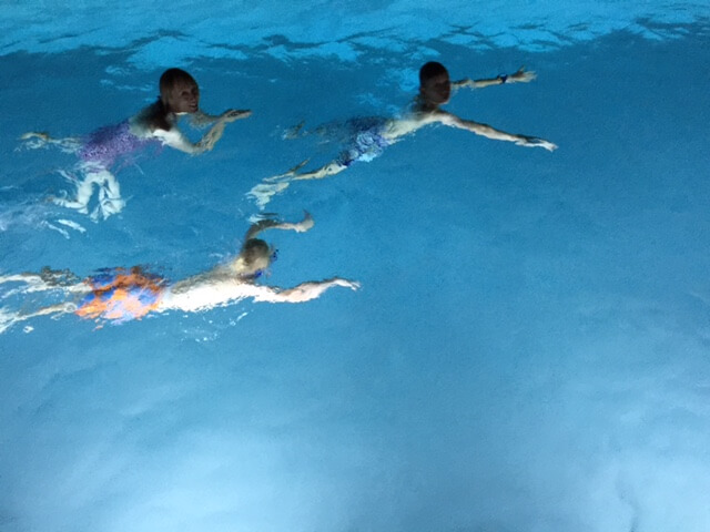 Three swimmers in a pool